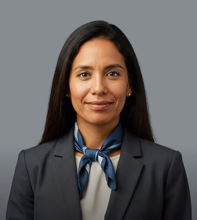 Mulher profissional de cabelo preto longo usando blazer escuro e lenço azul no pescoço.